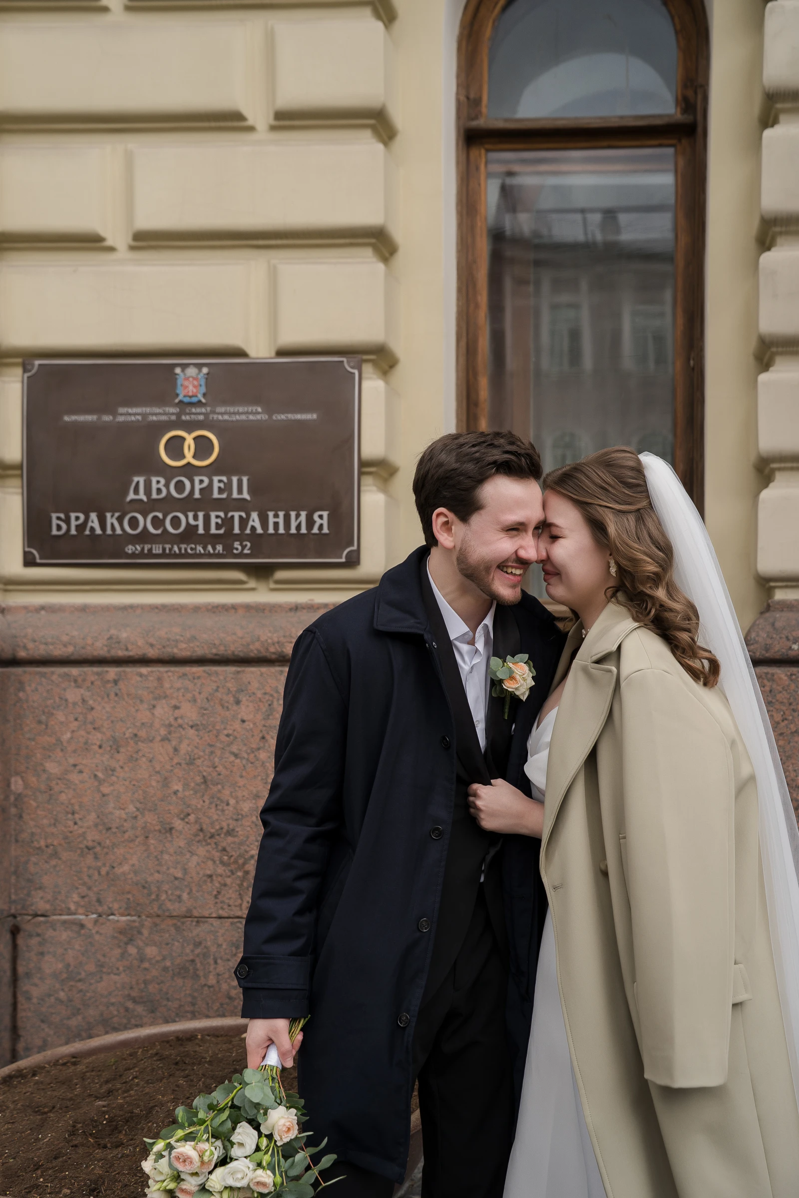 Молодожёны у таблички Дворца бракосочетания на Фурштатской улице