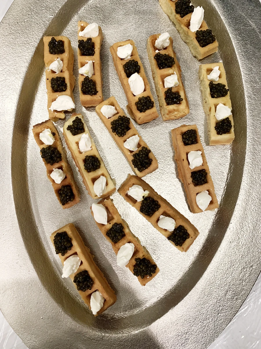 Вафли с чёрной икрой и сливочным муссом на серебряном подносе