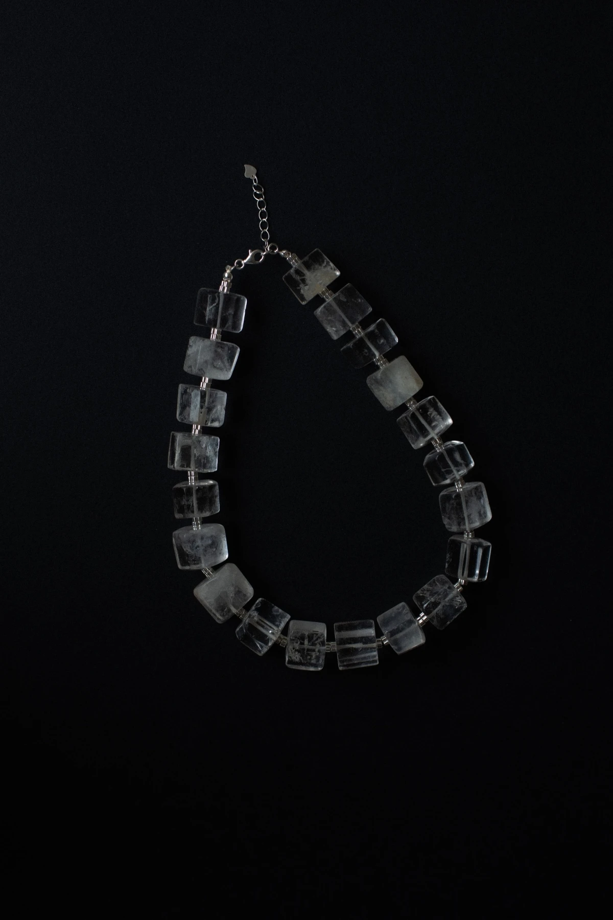 Колье из прозрачных квадратных кварцевых бусин на чёрном фоне