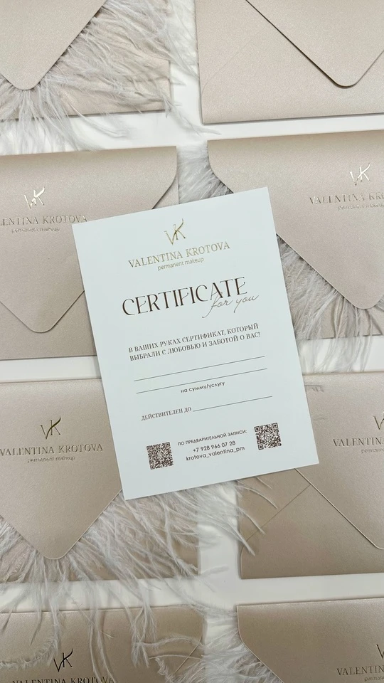 Подарочный сертификат на фоне бежевых конвертов с перьями