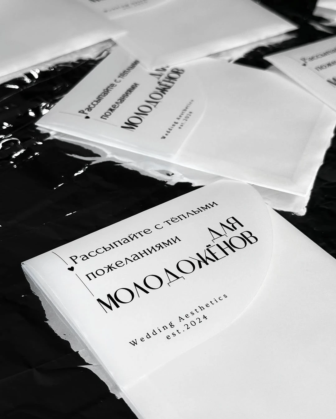 Стопка белых буклетов «Для молодожёнов» с пожеланиями на тёмном фоне