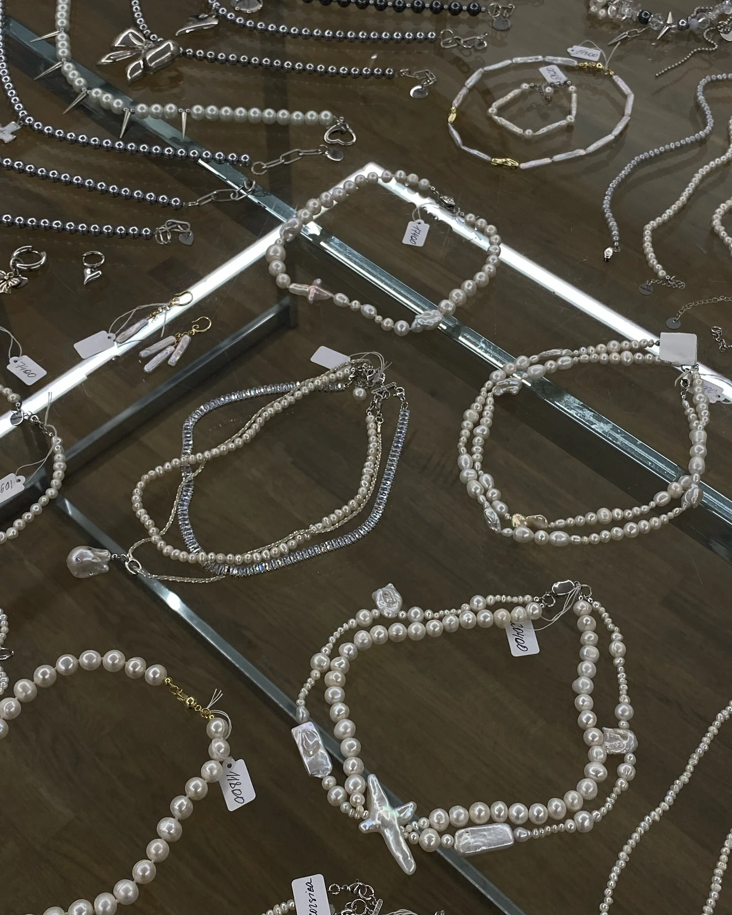 Жемчужные браслеты и колье с крестами на витрине с ценниками