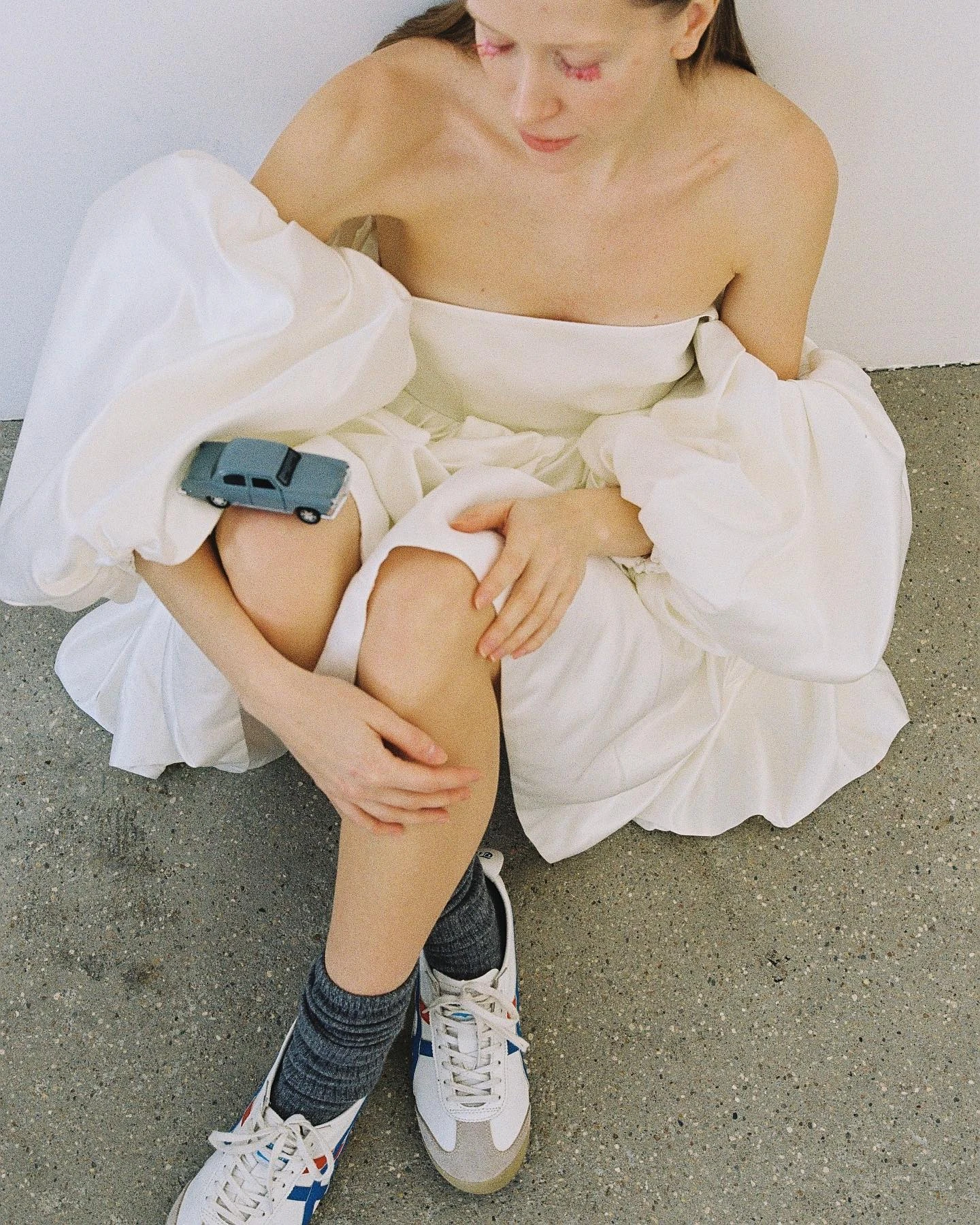 платье с открытыми плечами и кроссовками на модели