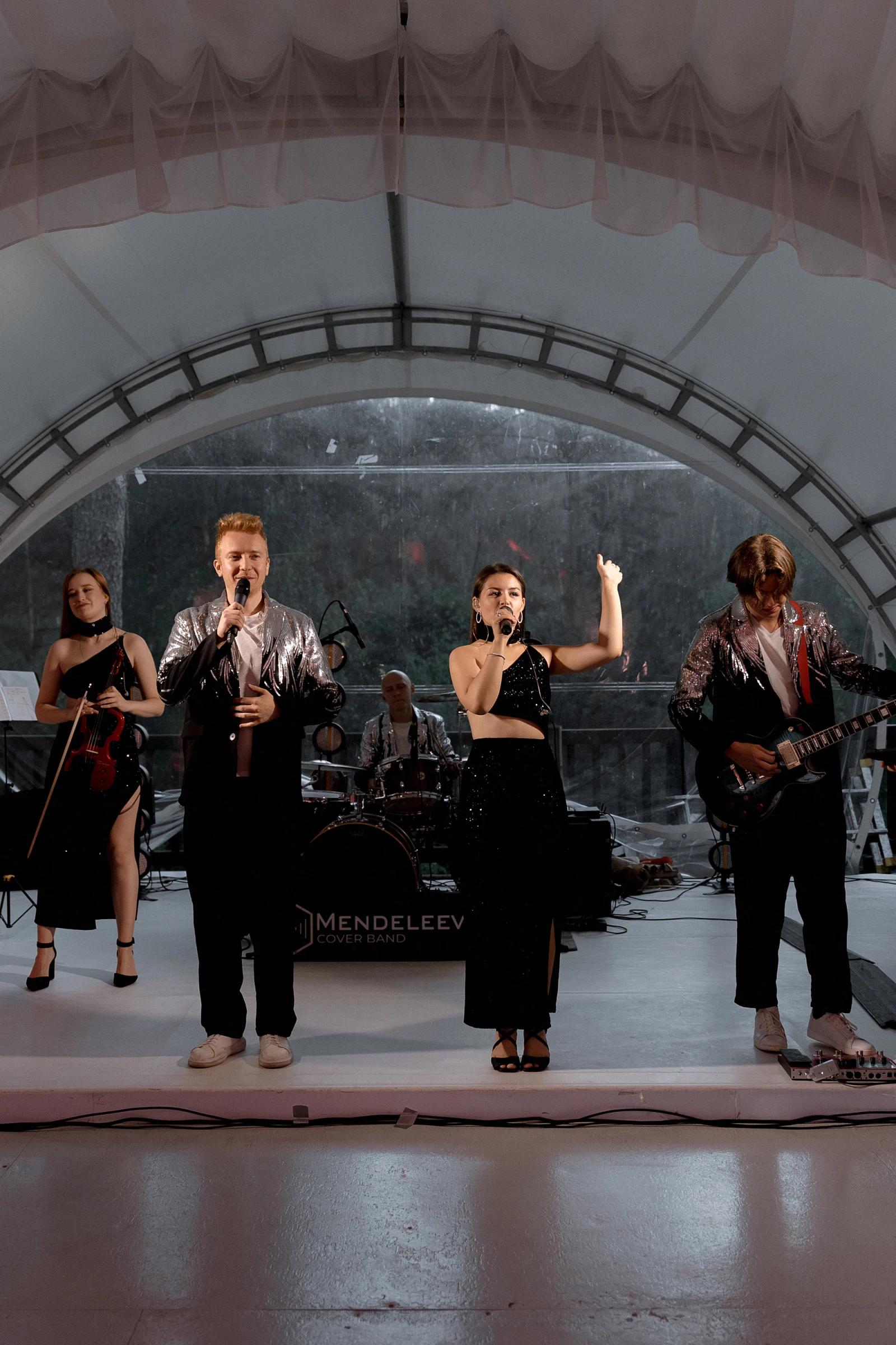 Кавер-группа Mendeleev Band выступает на сцене в шатре на свадьбе