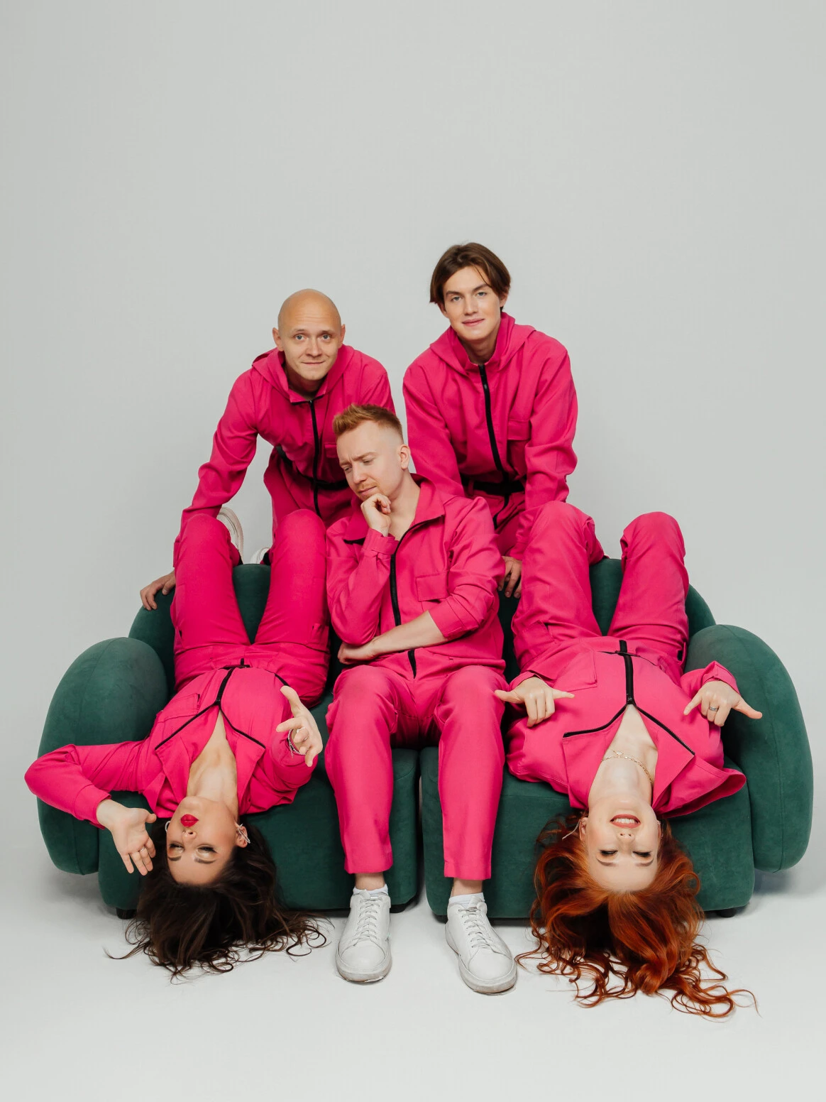 Артисты Mendeleev Band в розовых костюмах на зелёном диване в студии