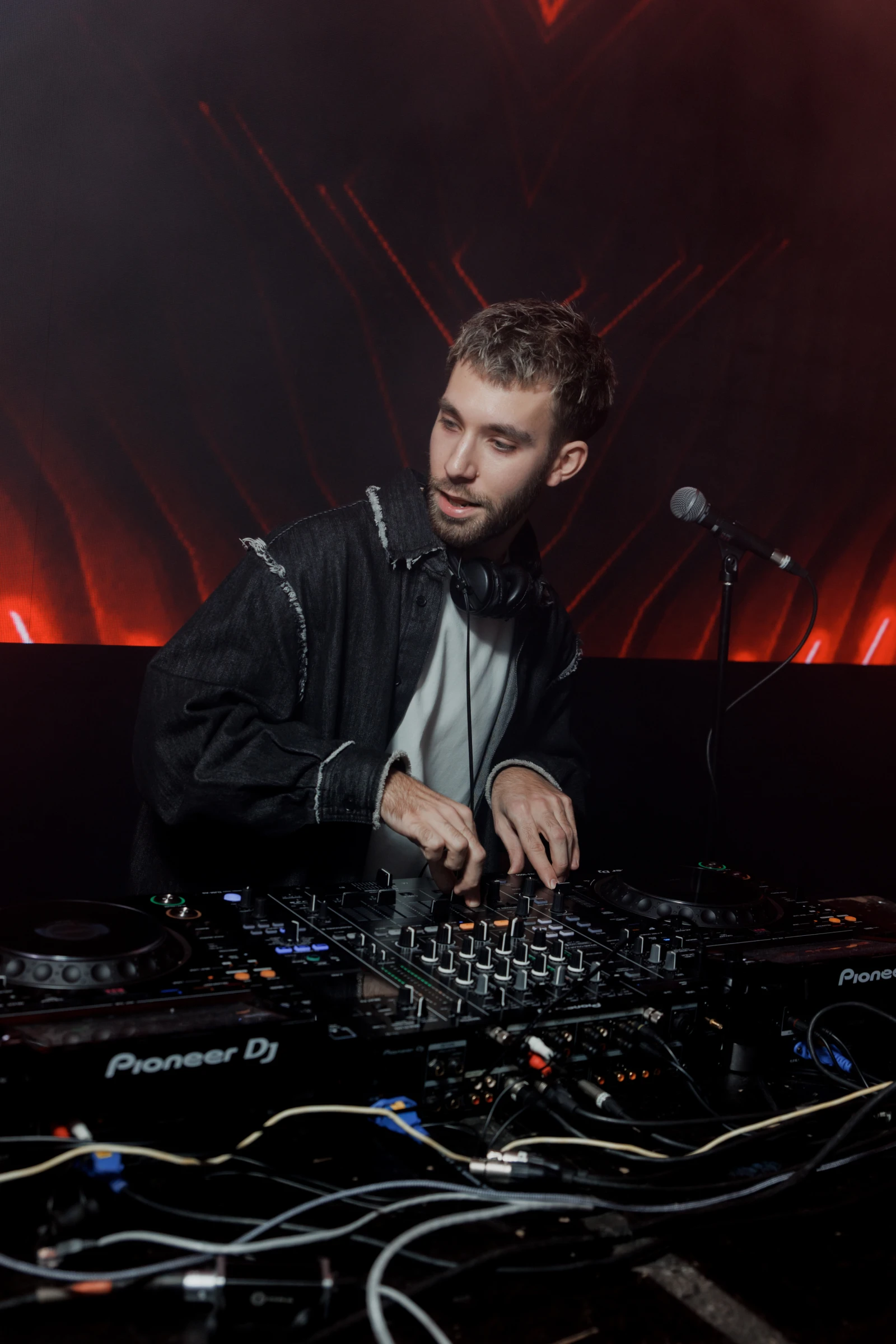 диджей за пультом pioneer с микрофоном на сцене