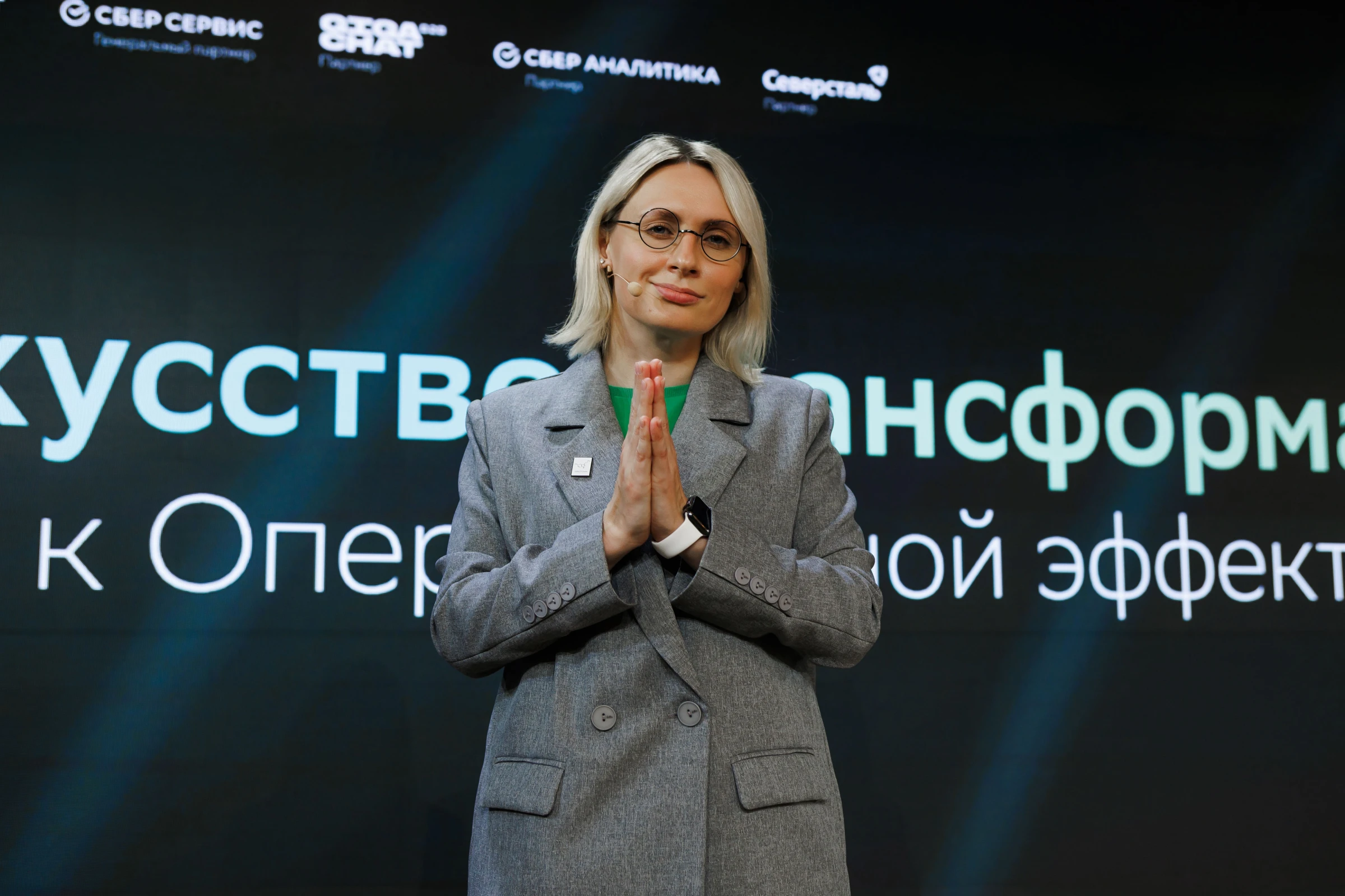 Женщина искренне смеётся в декорированном праздничными огнями зале