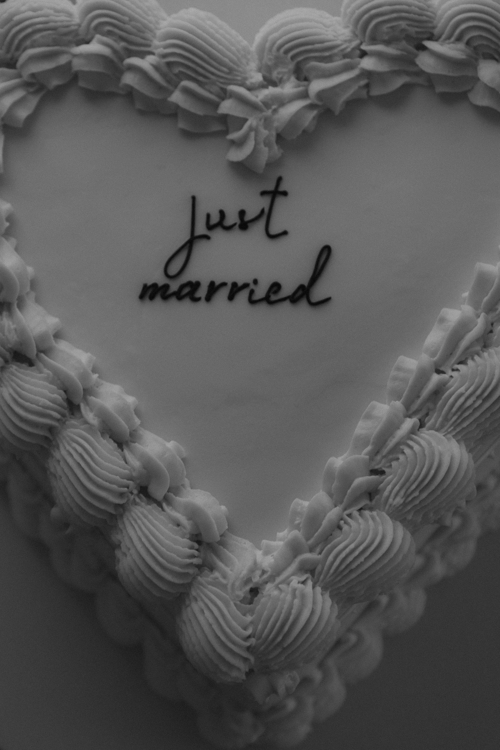 свадебный торт в форме сердца с кремовым узором и надписью just married