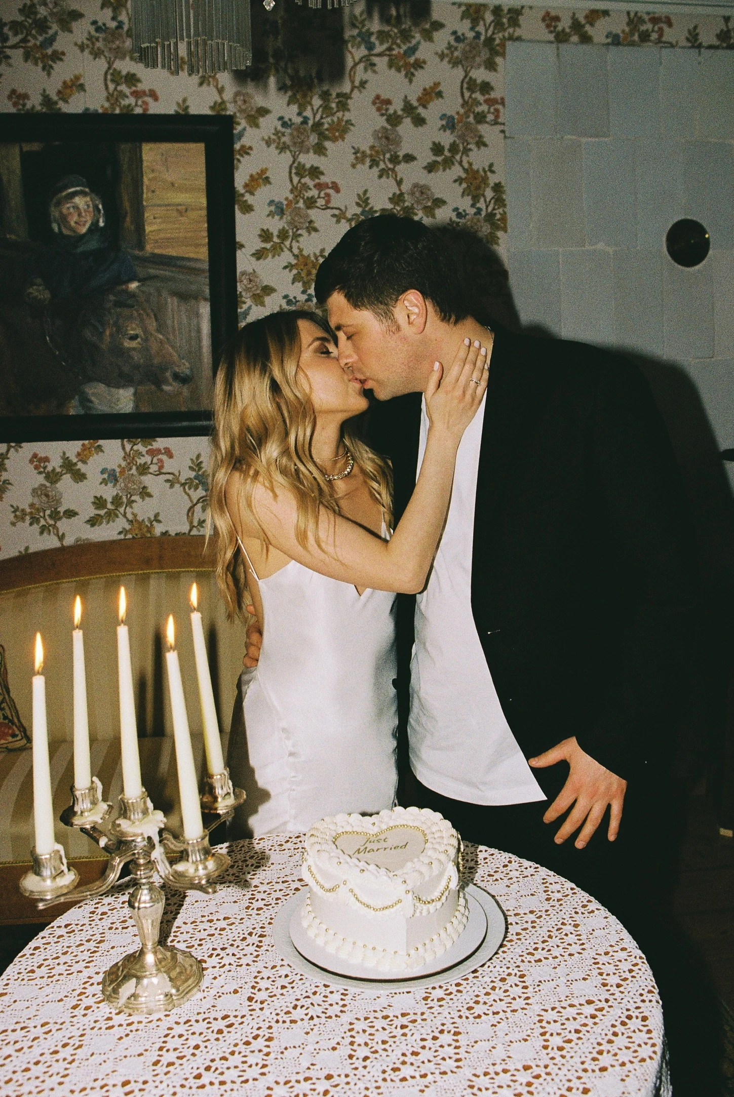 белый торт сердце с надписью just married на столе со свечами в винтажном интерьере