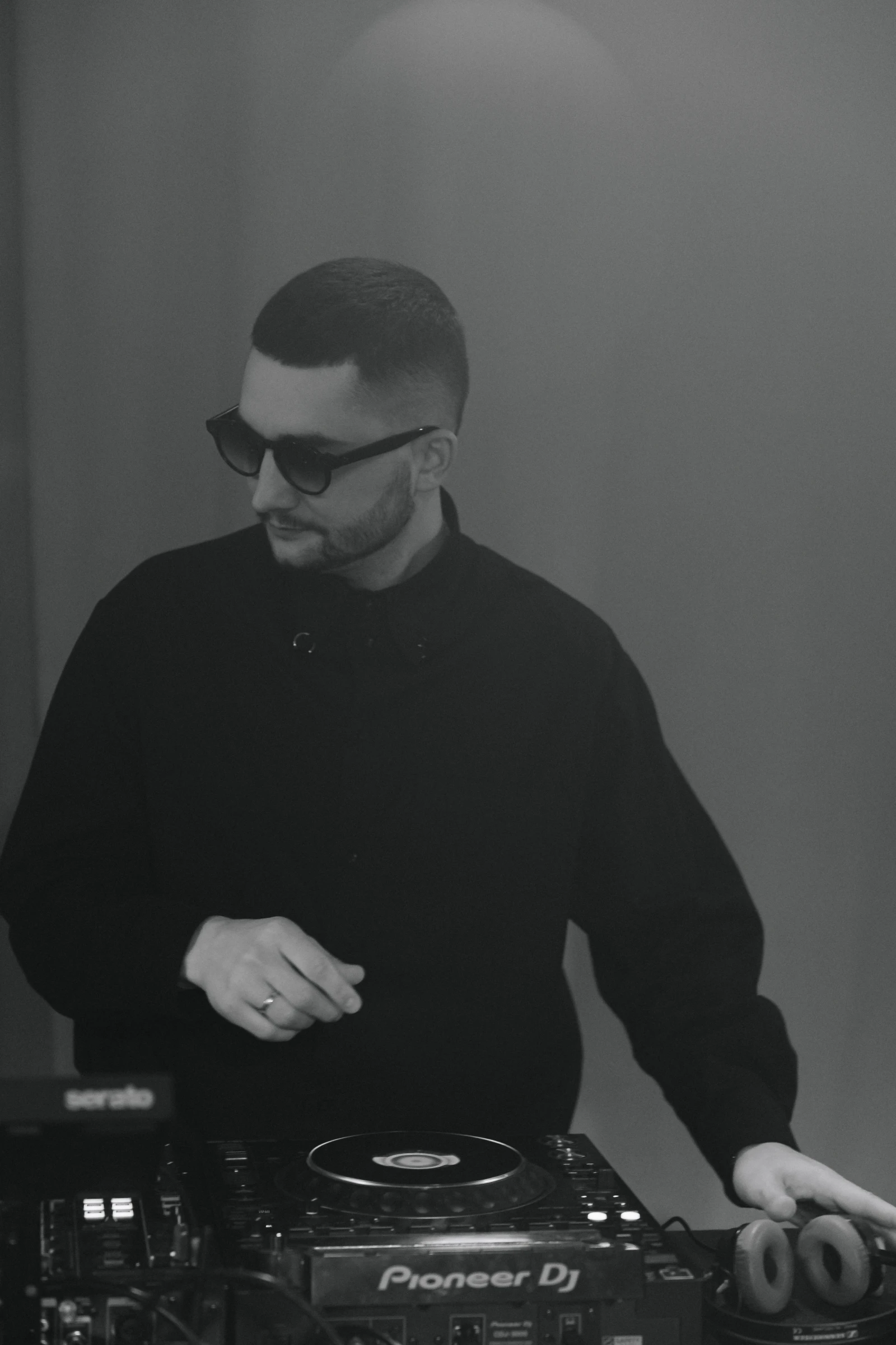 диджей в очках работает за пультом Pioneer DJ на выступлении