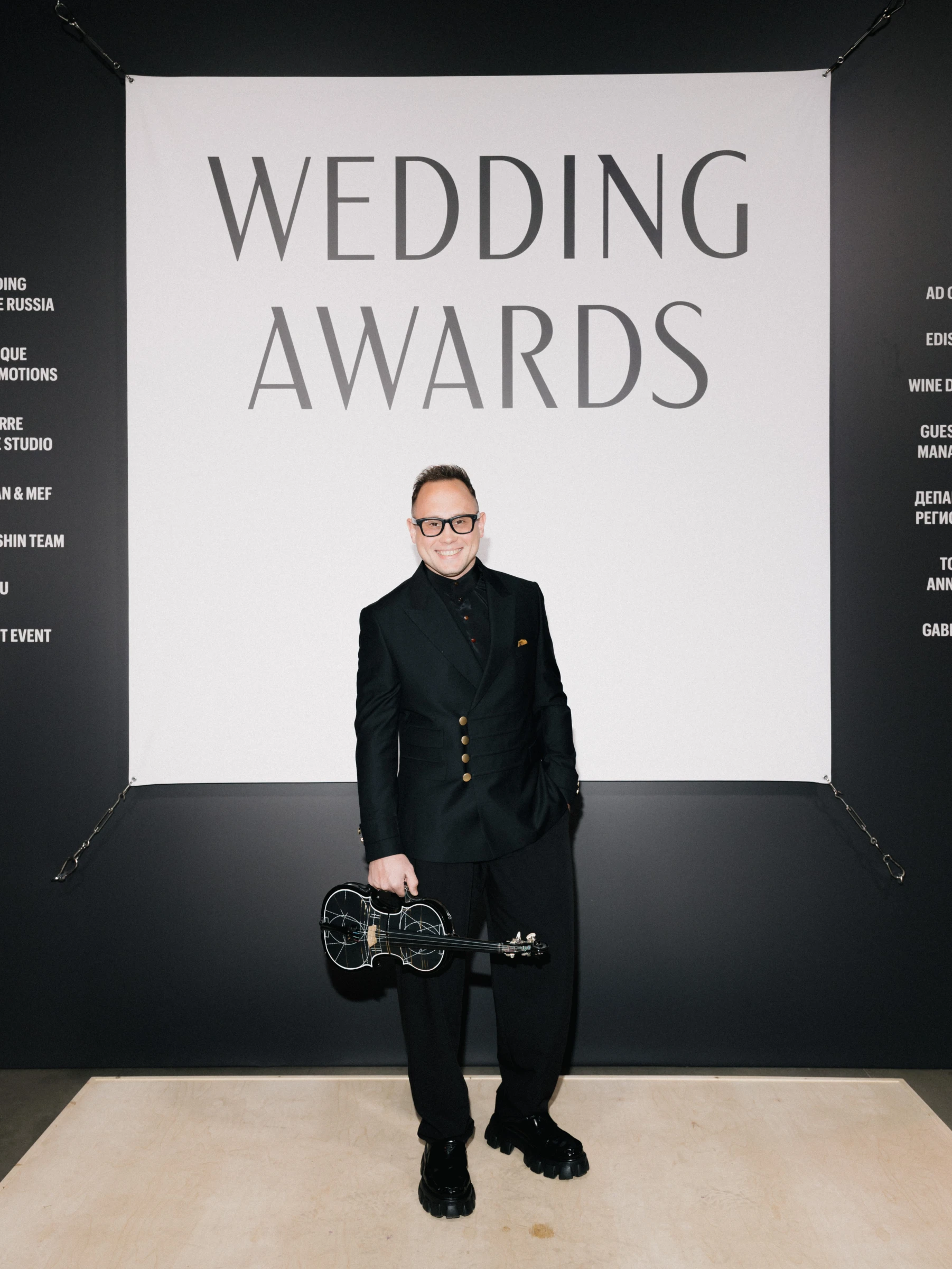 диджей со скрипкой позирует на фотозоне премии Wedding Awards