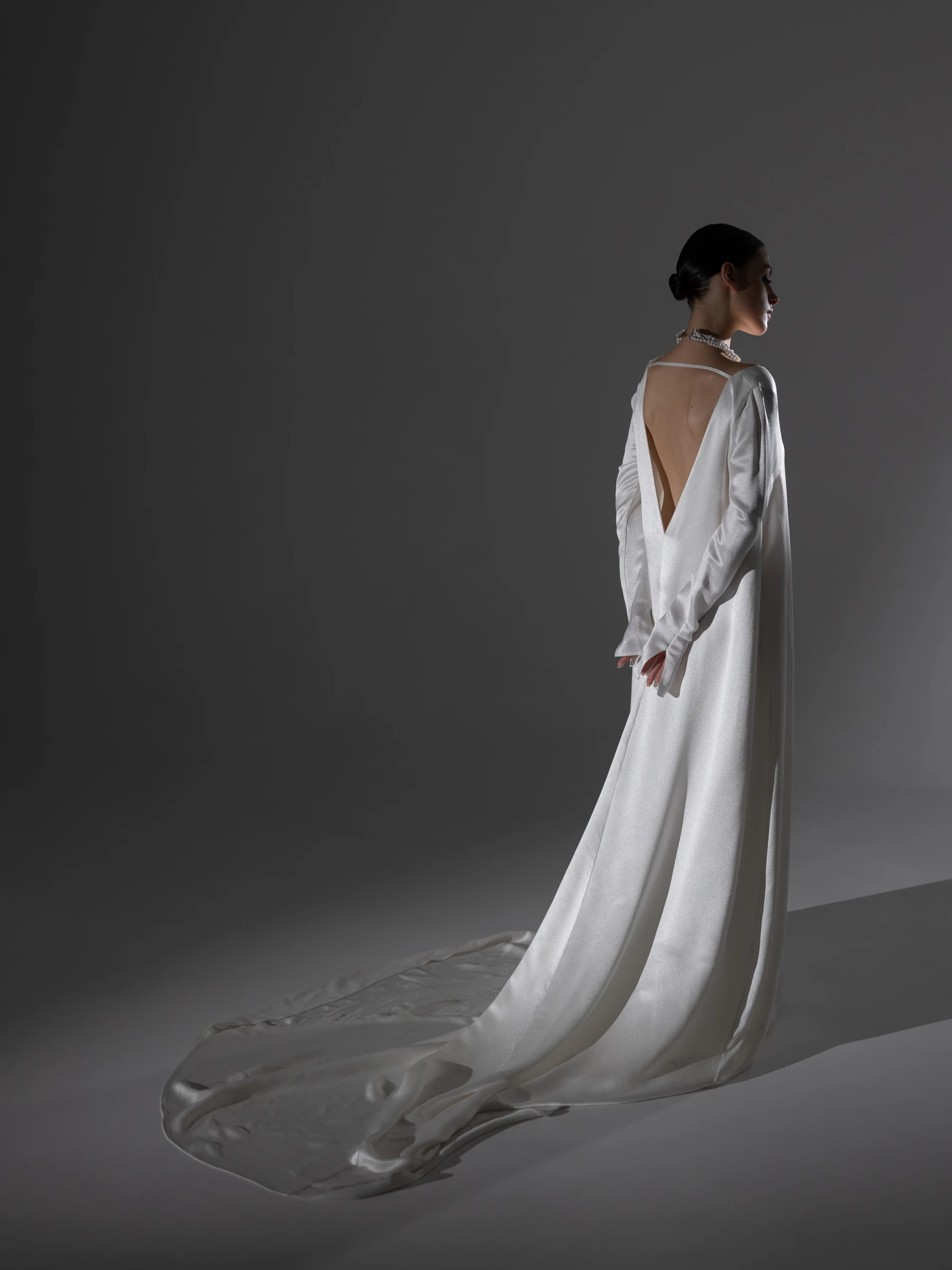 атласное платье со шлейфом и открытой спиной в студийном свете