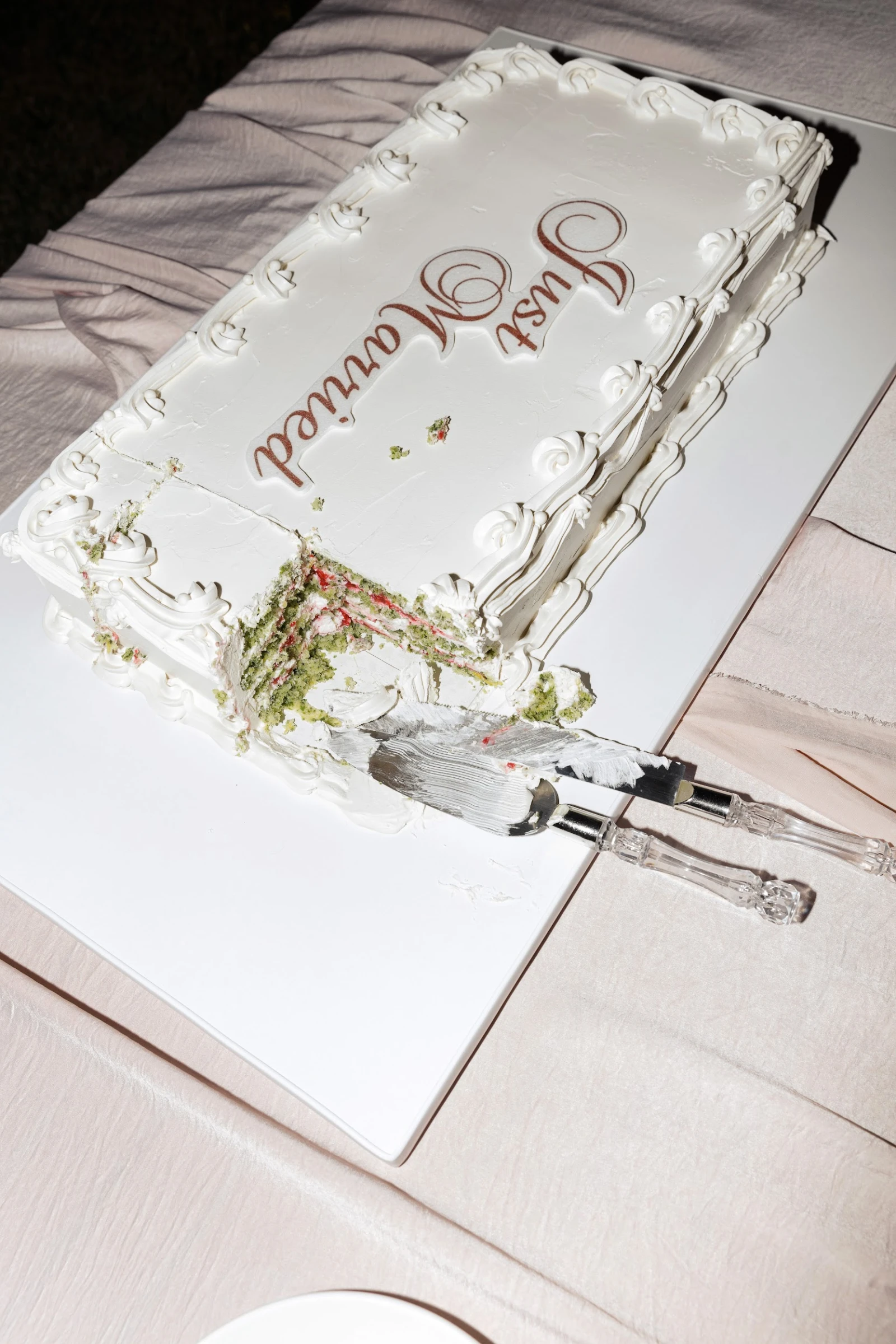 белый прямоугольный торт с рельефным бортом и надписью Just Married в разрезе с фисташково-ягодной начинкой