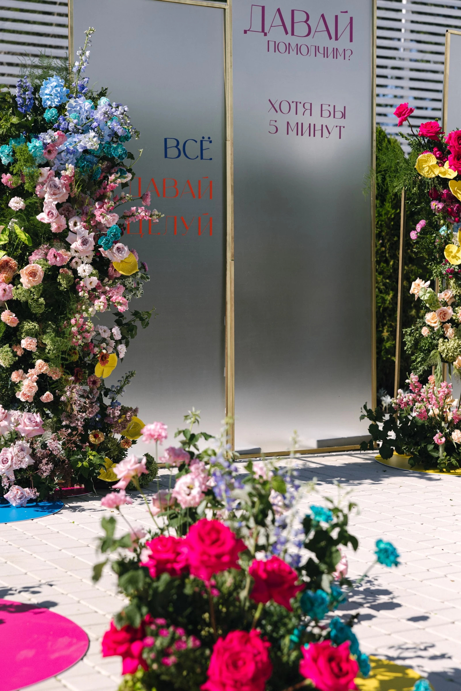 Яркая фотозона с цветами и надписями на свадебной вечеринке