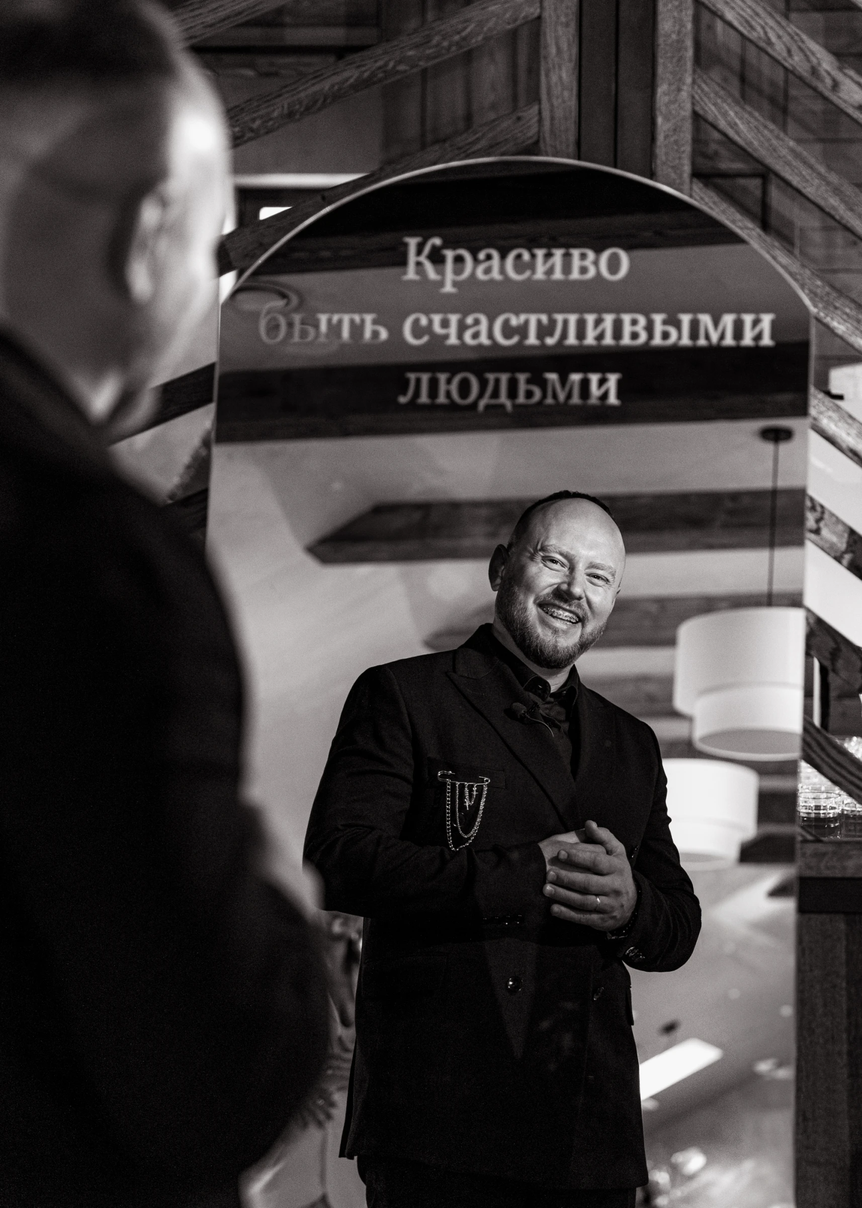 чёрно-белый портрет ведущего свадьбы у зеркальной арки