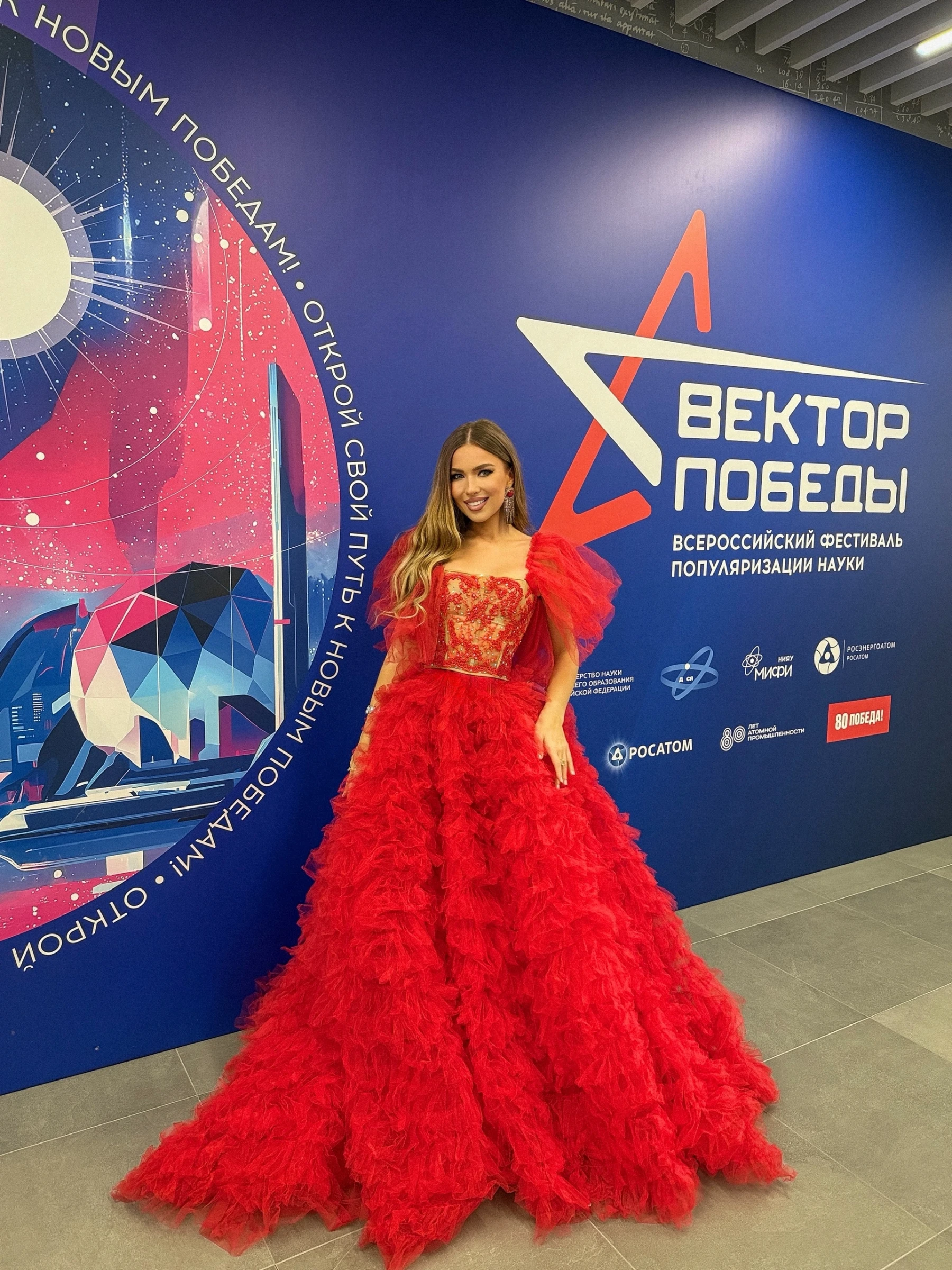 Ведущая в пышном красном платье с фатиновой юбкой на фотозоне фестиваля