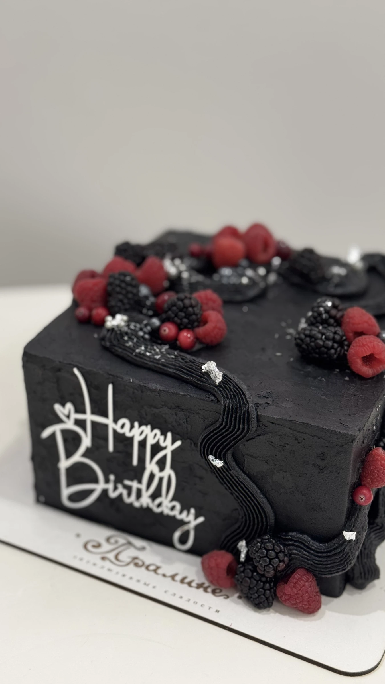 чёрный торт декорирован малиной ежевикой и серебряной поталью с топпером happy birthday