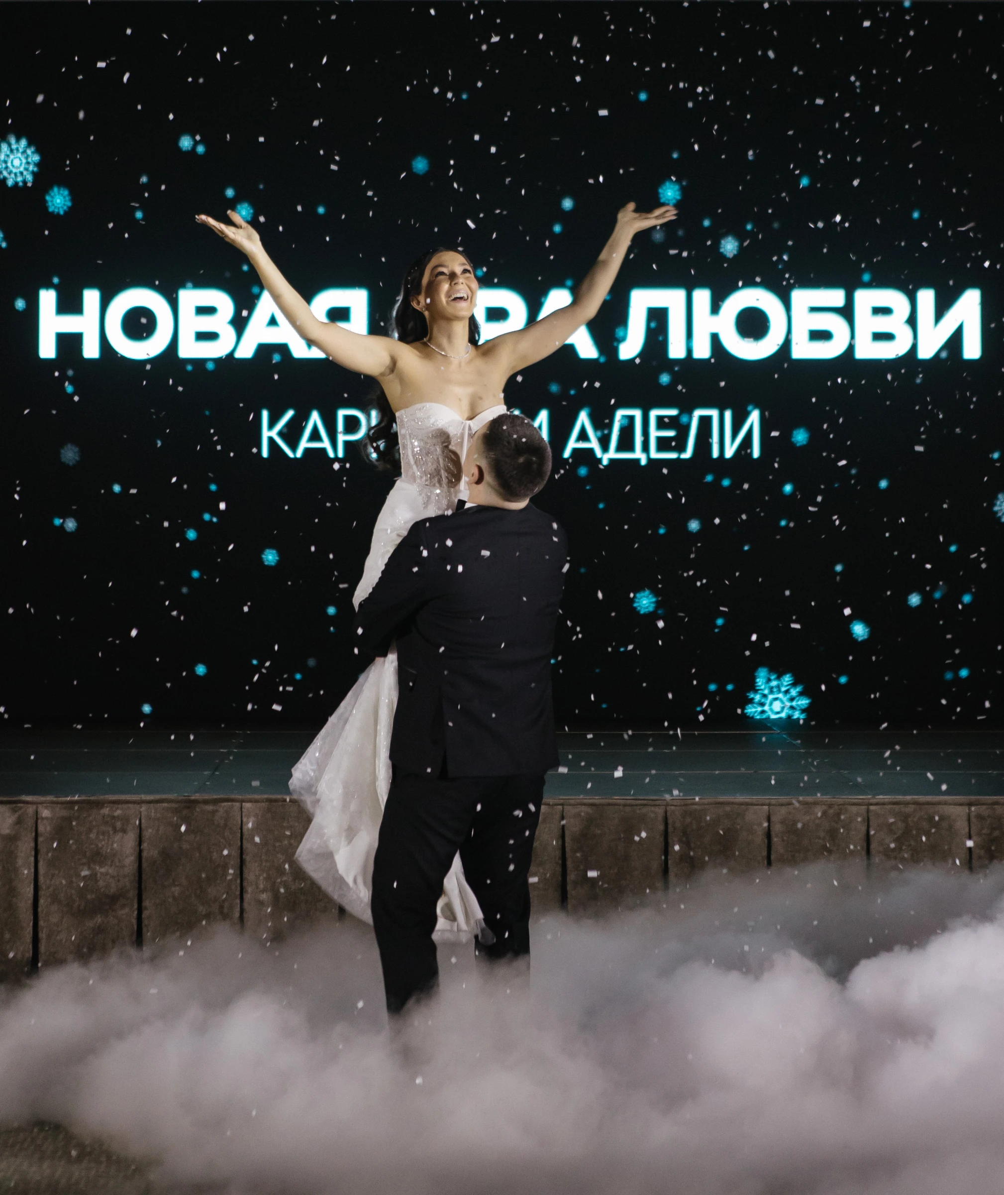 молодожёны танцуют на неоновой сцене с конфетти и снегом вечером