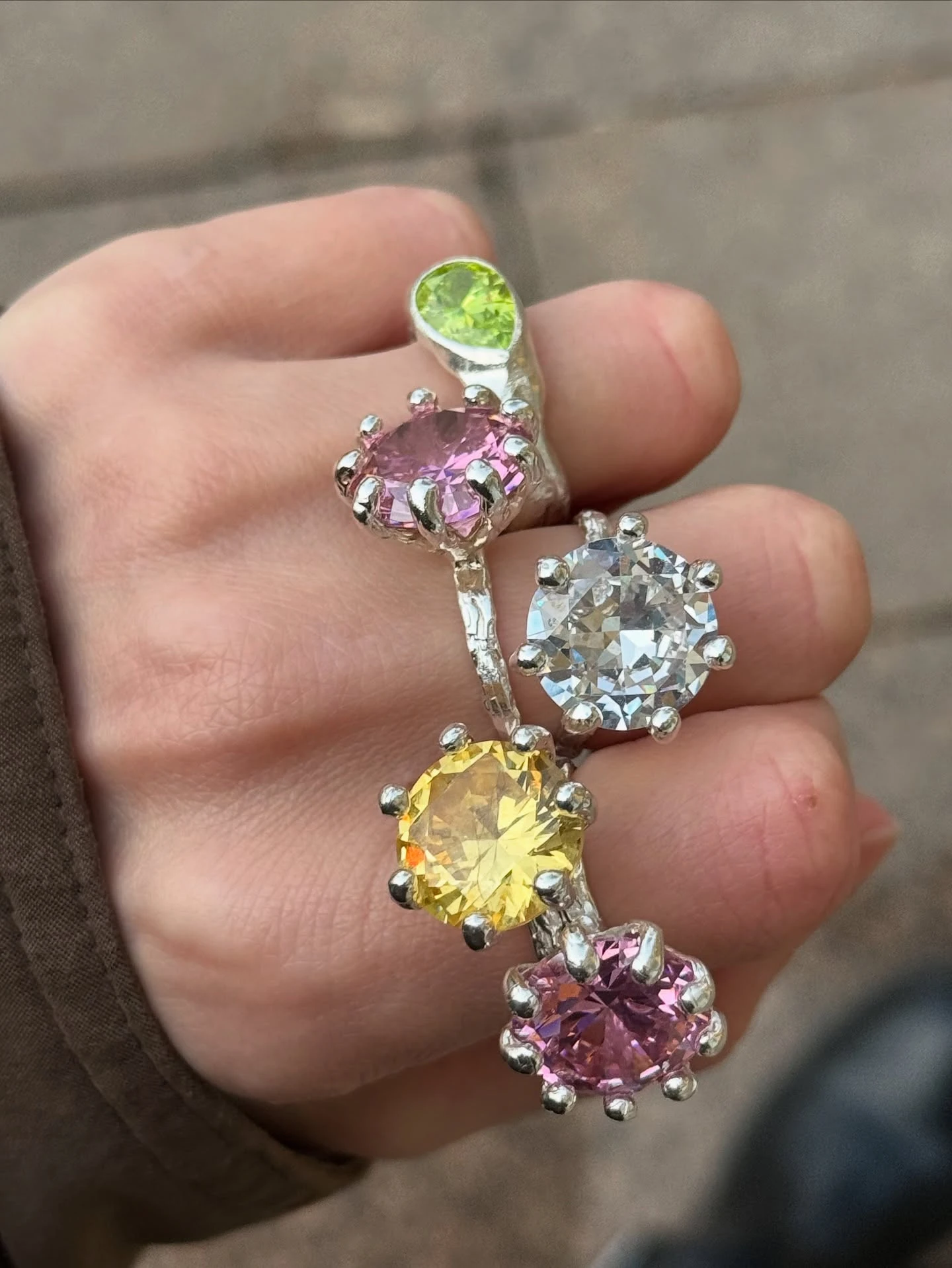 серебряные кольца с голубыми камнями на пальцах на синем атласе