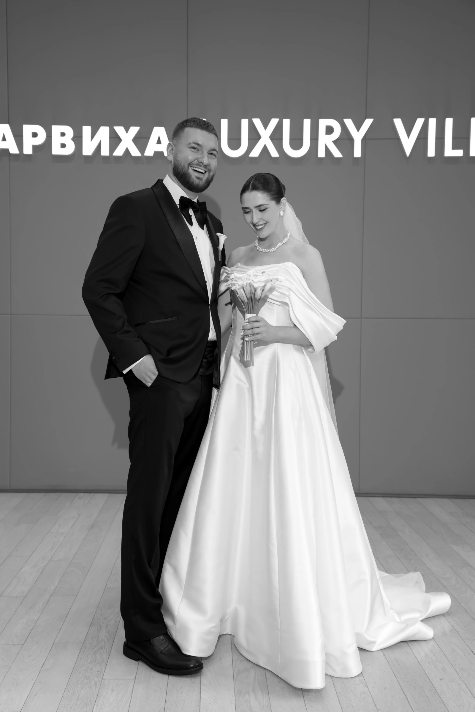 Пара в чёрно-белых образах у таблички Luxury Villa на съёмке