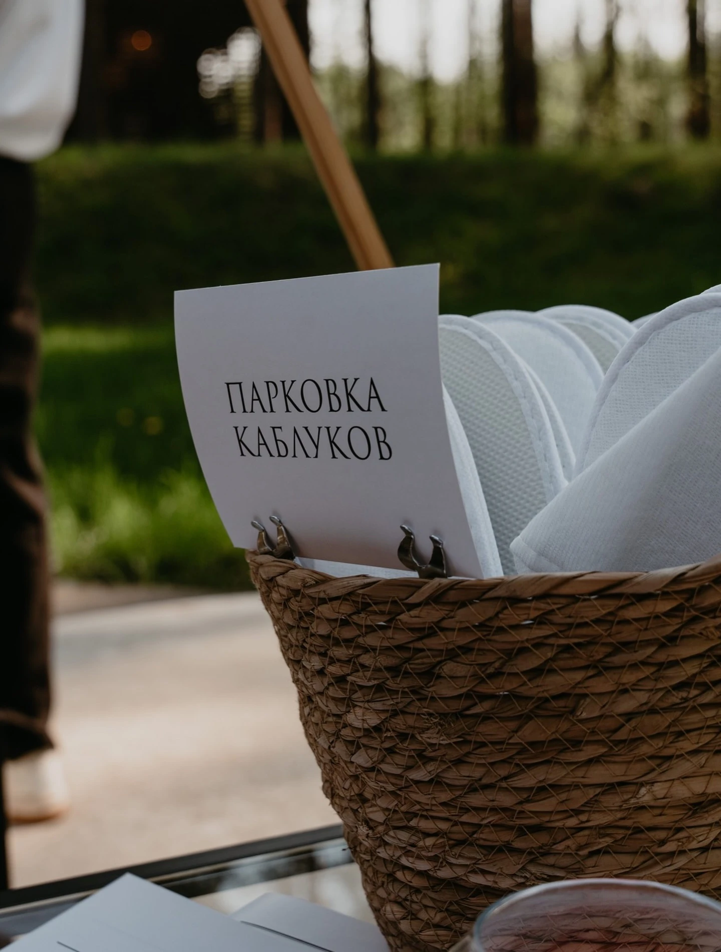 плетёная корзина с тапочками и табличкой парковки каблуков на церемонии