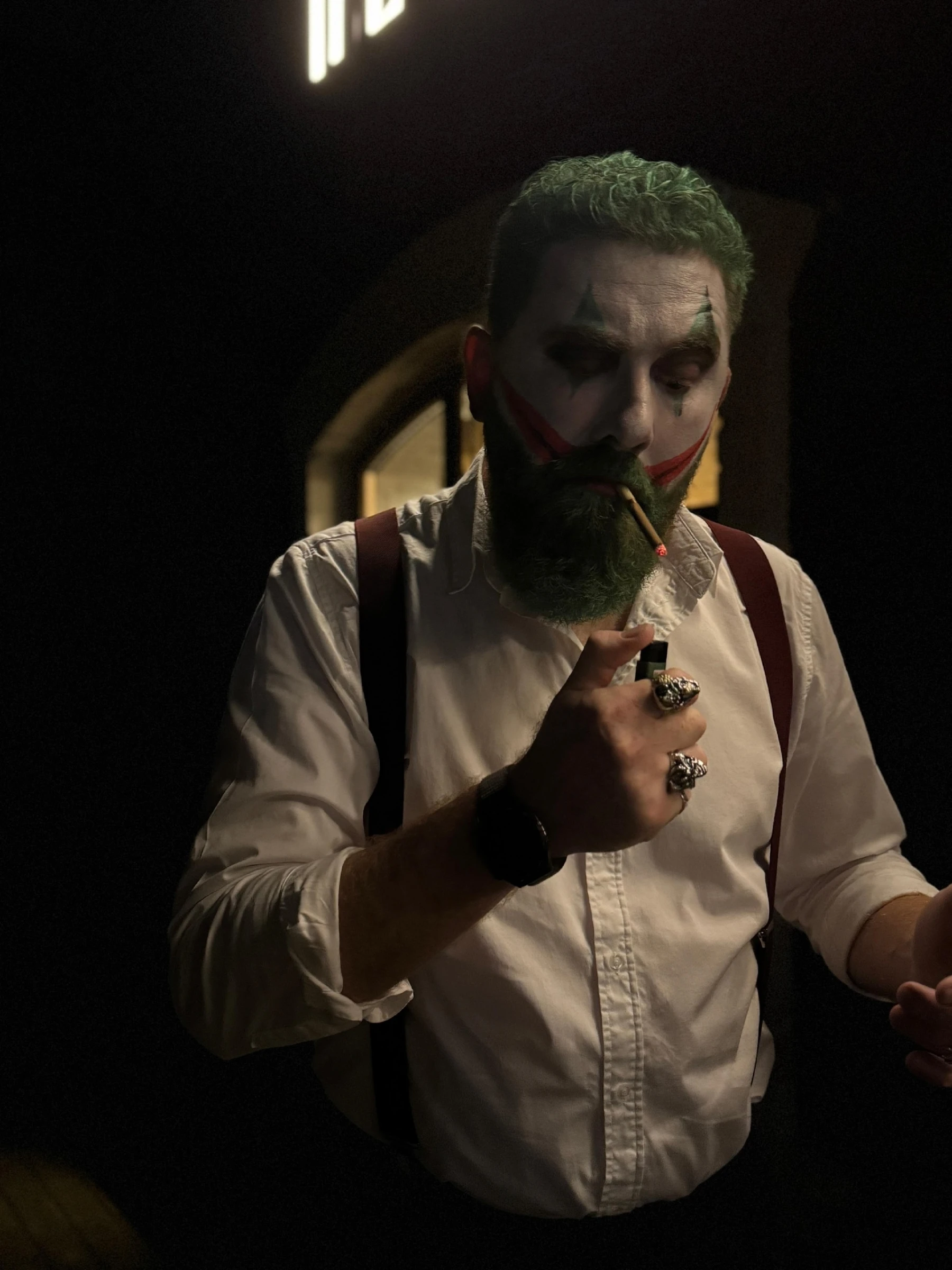ведущий в гриме джокера с сигаретой крупным планом в белой рубашке