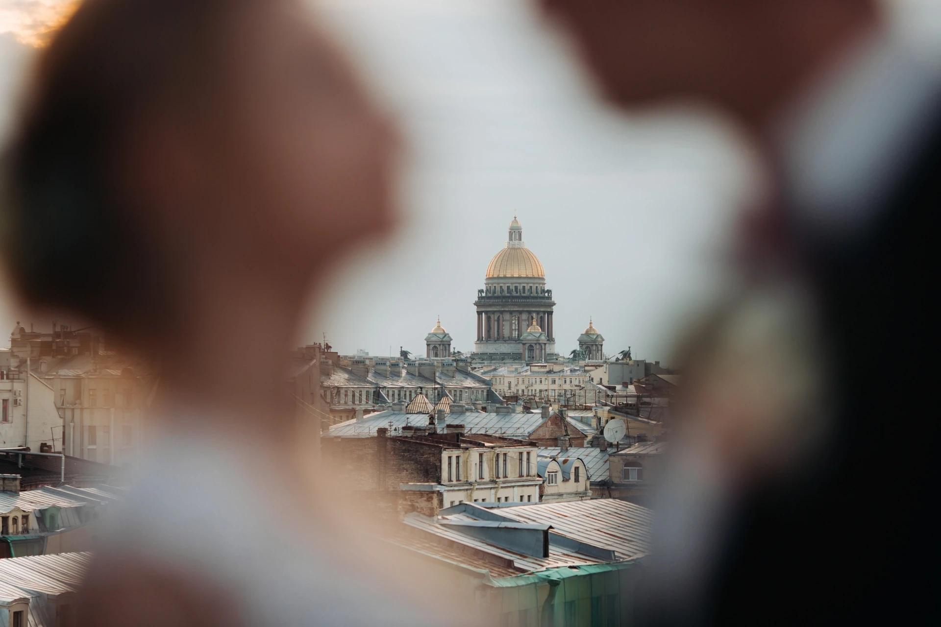 жених и невеста на переднем плане размыто, купол собора на заднем плане