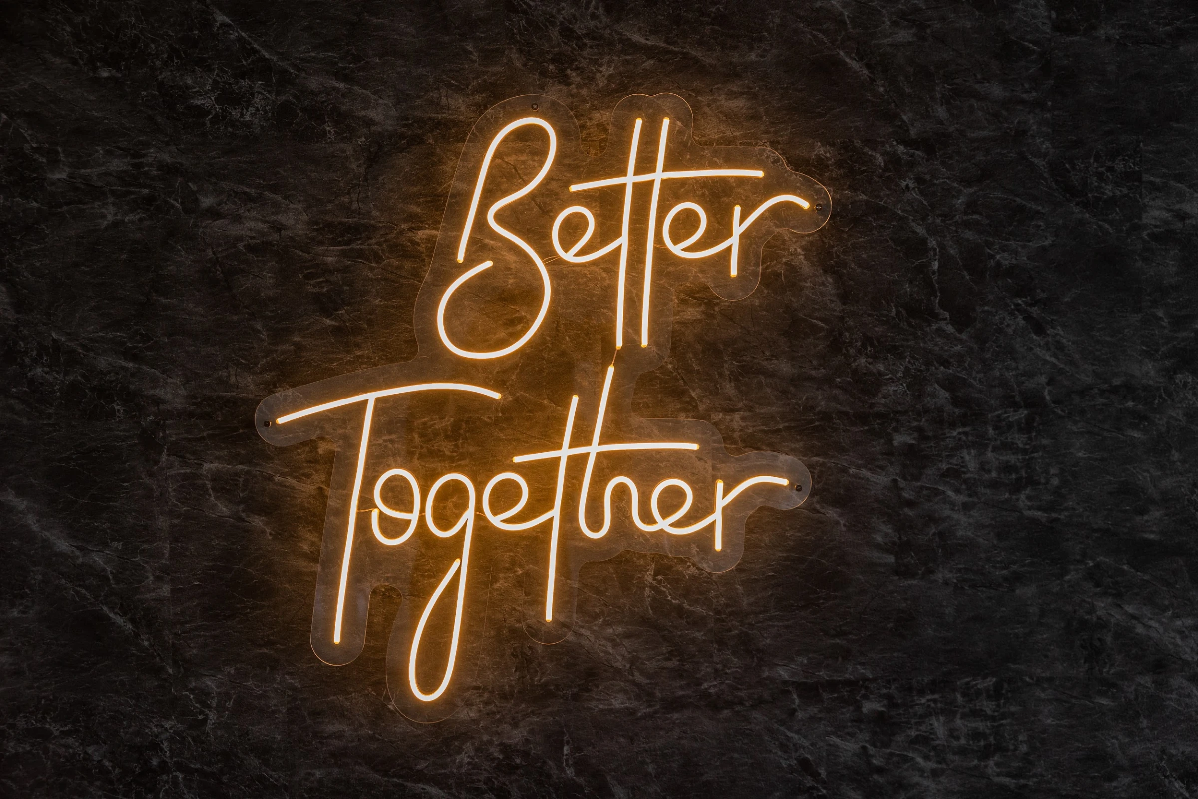 неоновая вывеска better together на тёмной каменной стене