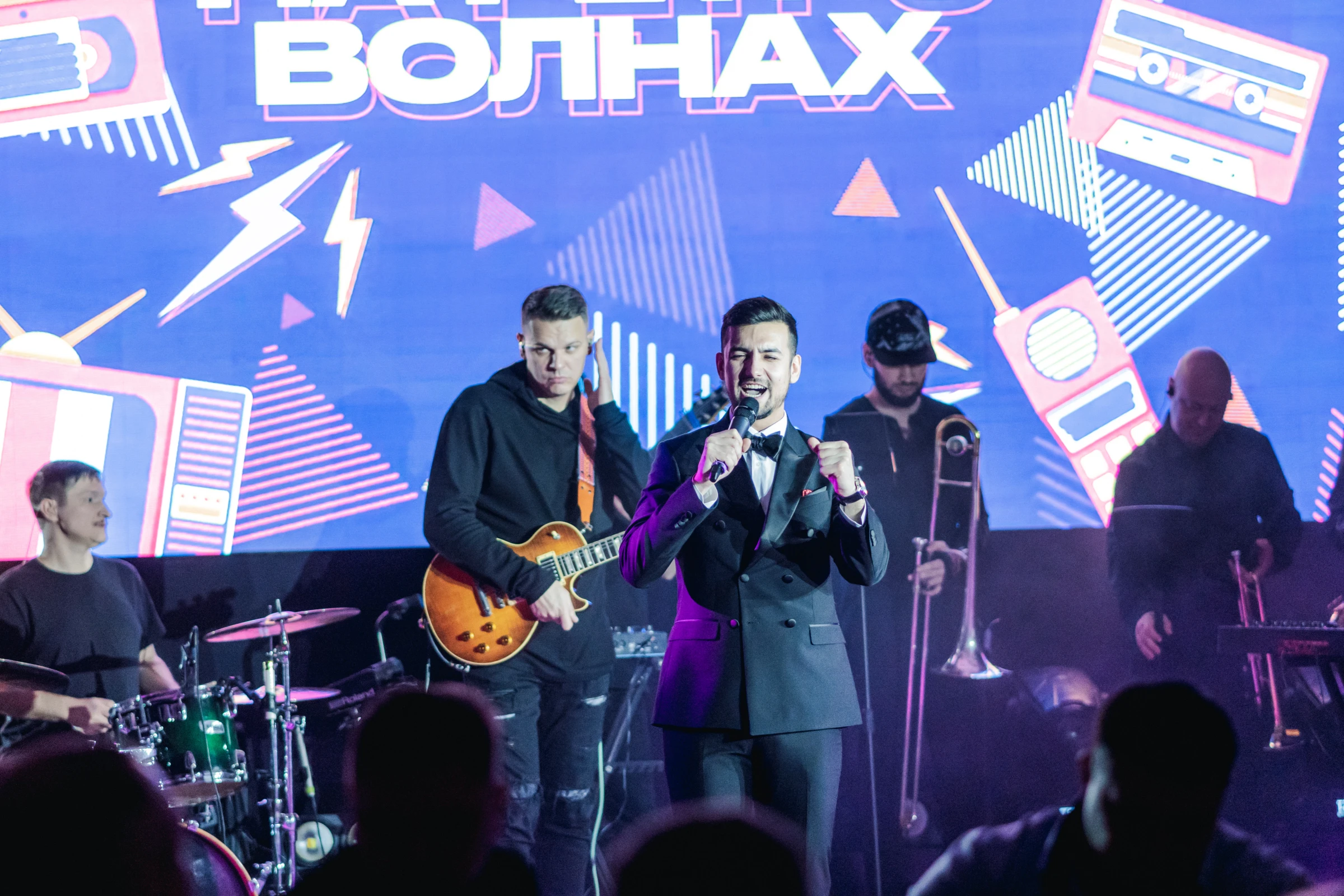 ведущий с живой группой на неоновой сцене праздника