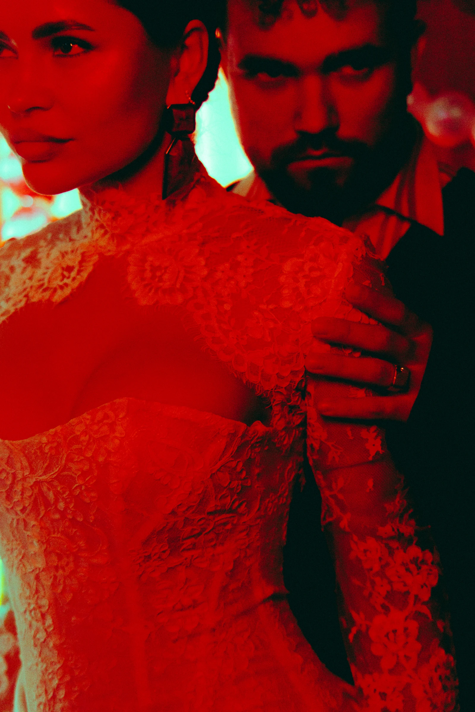 невеста в кружевном платье и жених крупным планом в алом свете