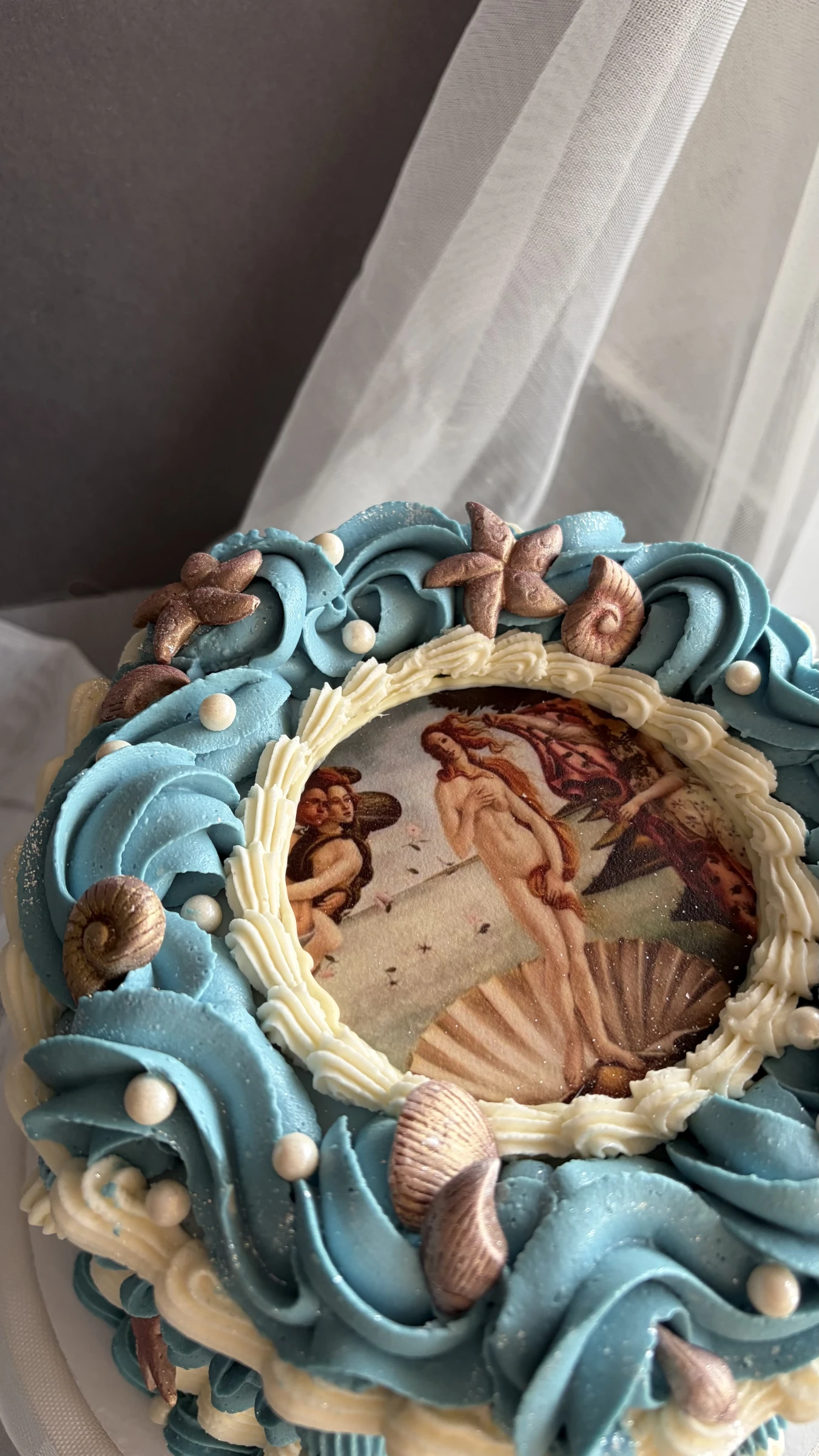 Крупный план торта с ракушками и съедобной картиной мифологического сюжета