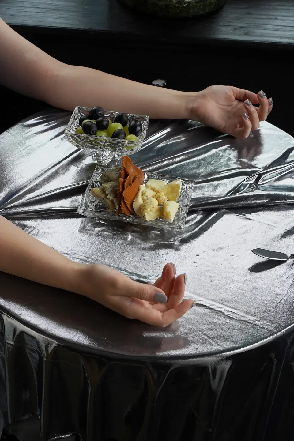 закуски с оливками и сыром на серебристой скатерти стола