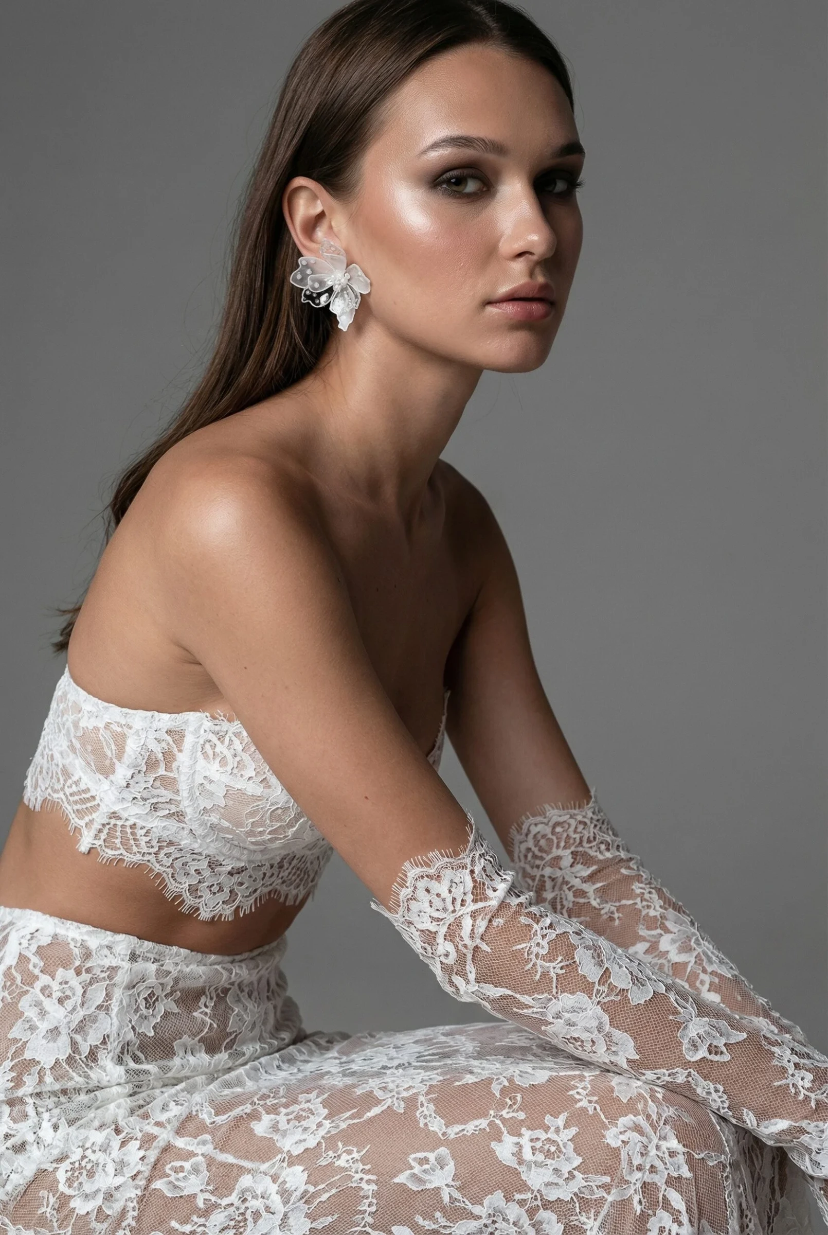 серьга-цветок на невесте в кружевных перчатках, портрет крупным планом