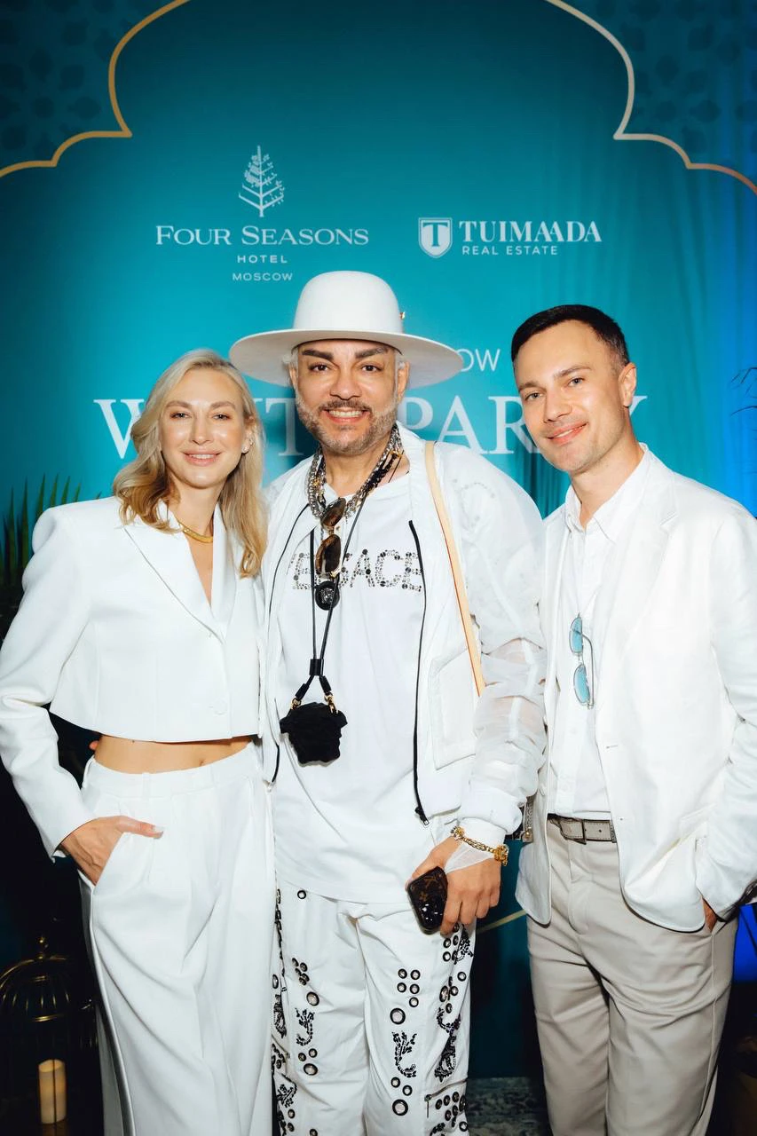 гости в белых нарядах на фоне баннера White Party