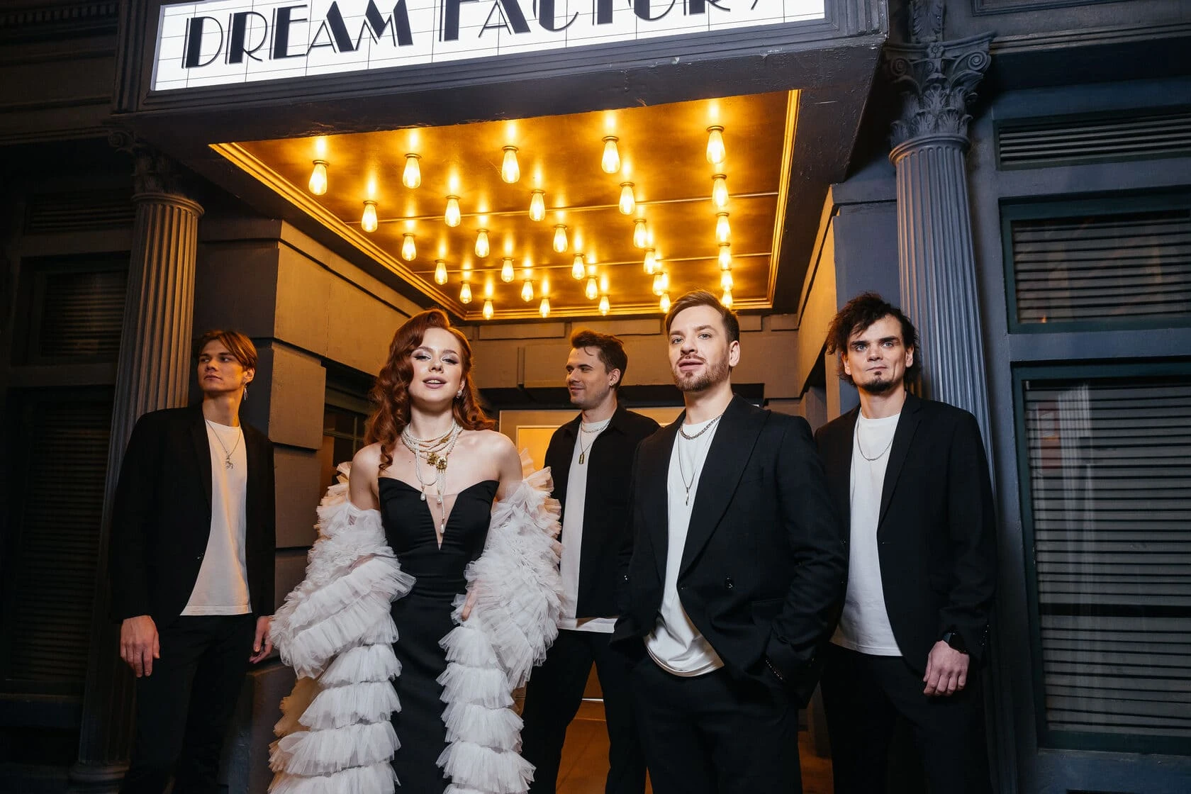 Музыканты и солистка в белом платье у вывески Dream Factory
