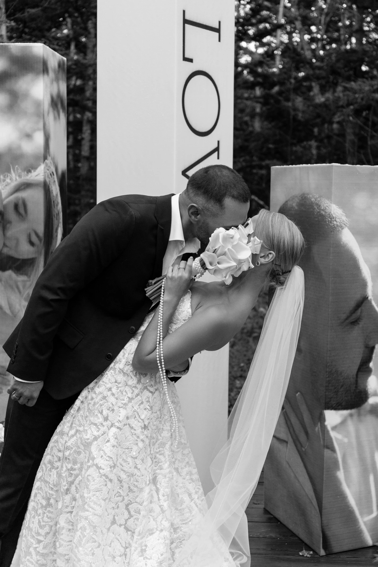 Жених и невеста целуются на фоне букв LOVE, чёрно-белое фото