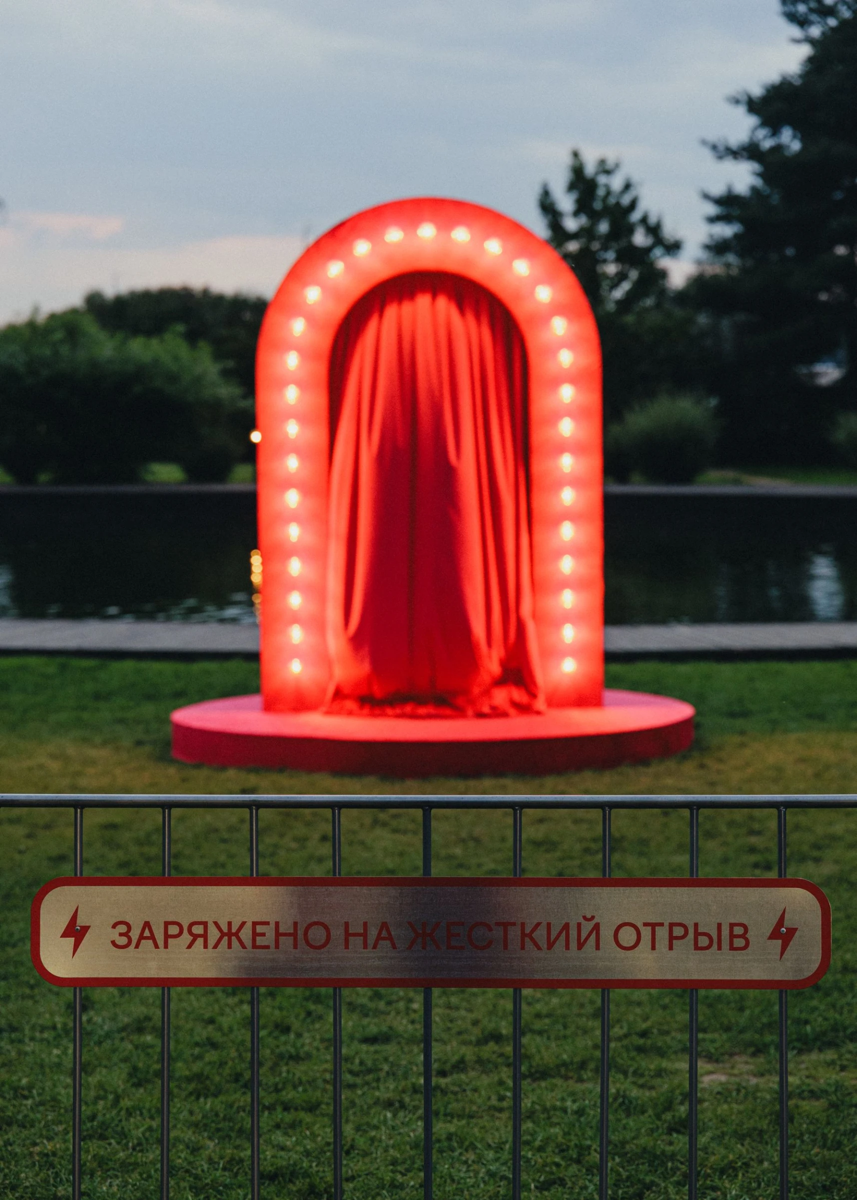 светящаяся красная арка с драпировкой и табличкой на ограждении