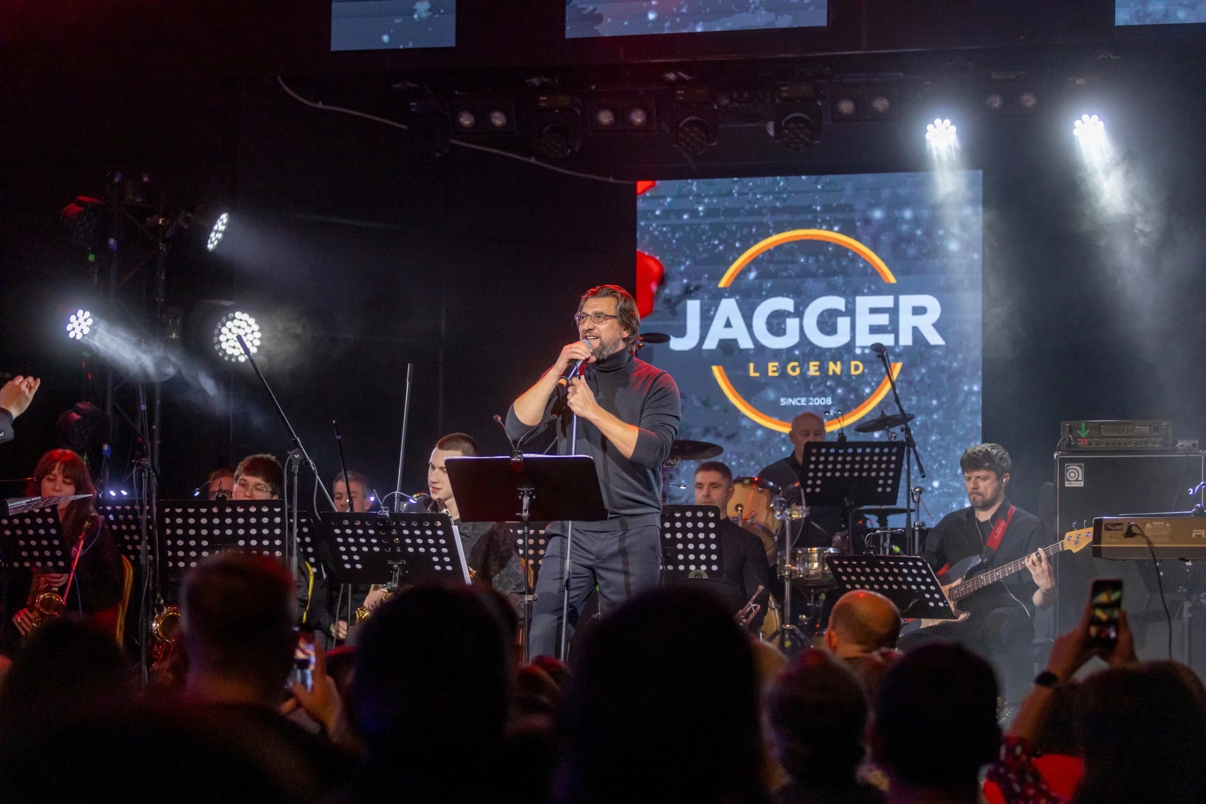 певец выступает на сцене фестиваля с вывеской Jagger Legend