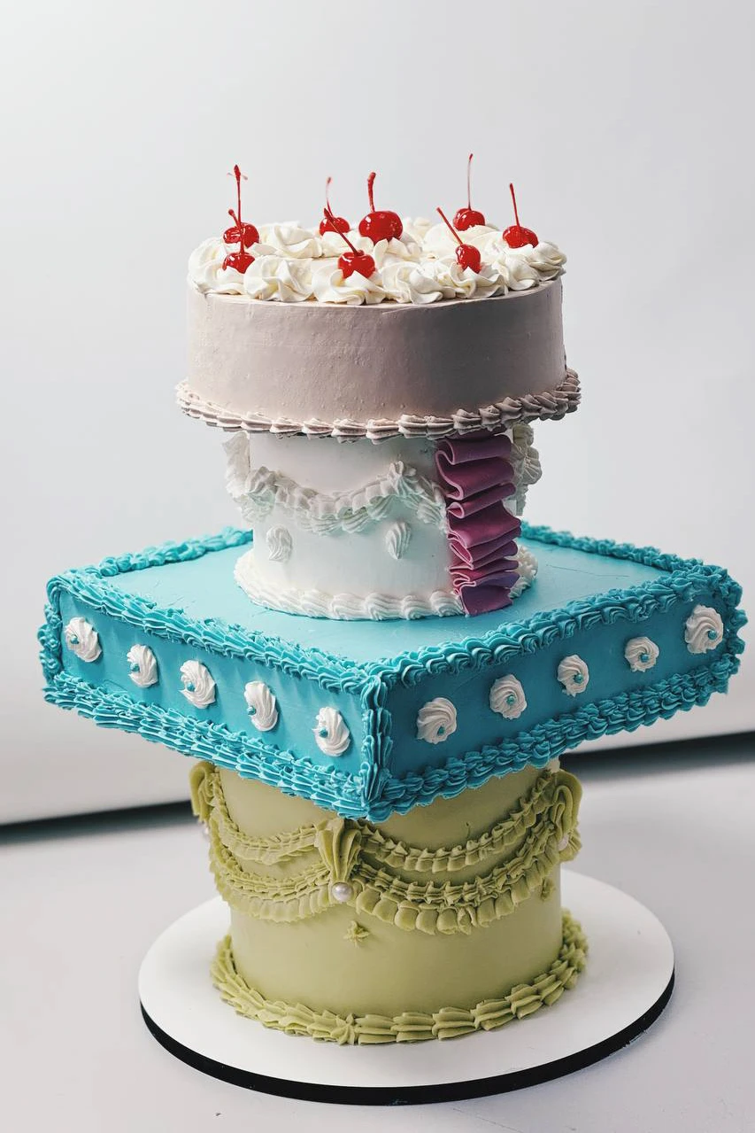 Асимметричный торт из смещённых бежевого бирюзового и мятного ярусов с вишенками