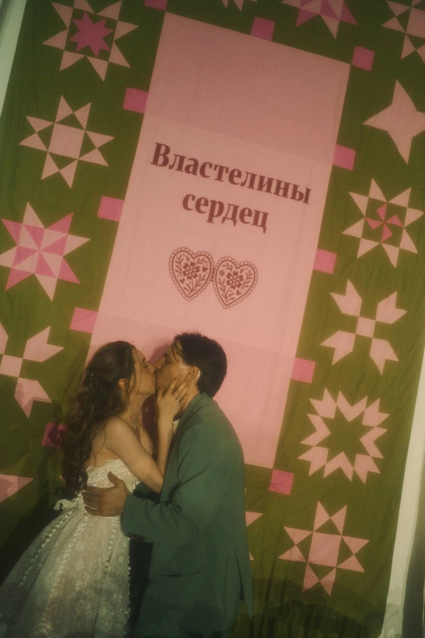 свадебная фотозона с баннером и парой на фоне декора