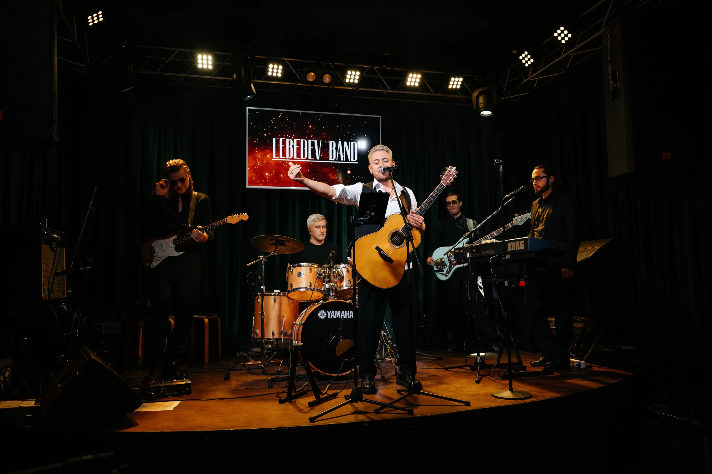 музыканты кавер-группы Lebedev Band выступают на сцене вечером