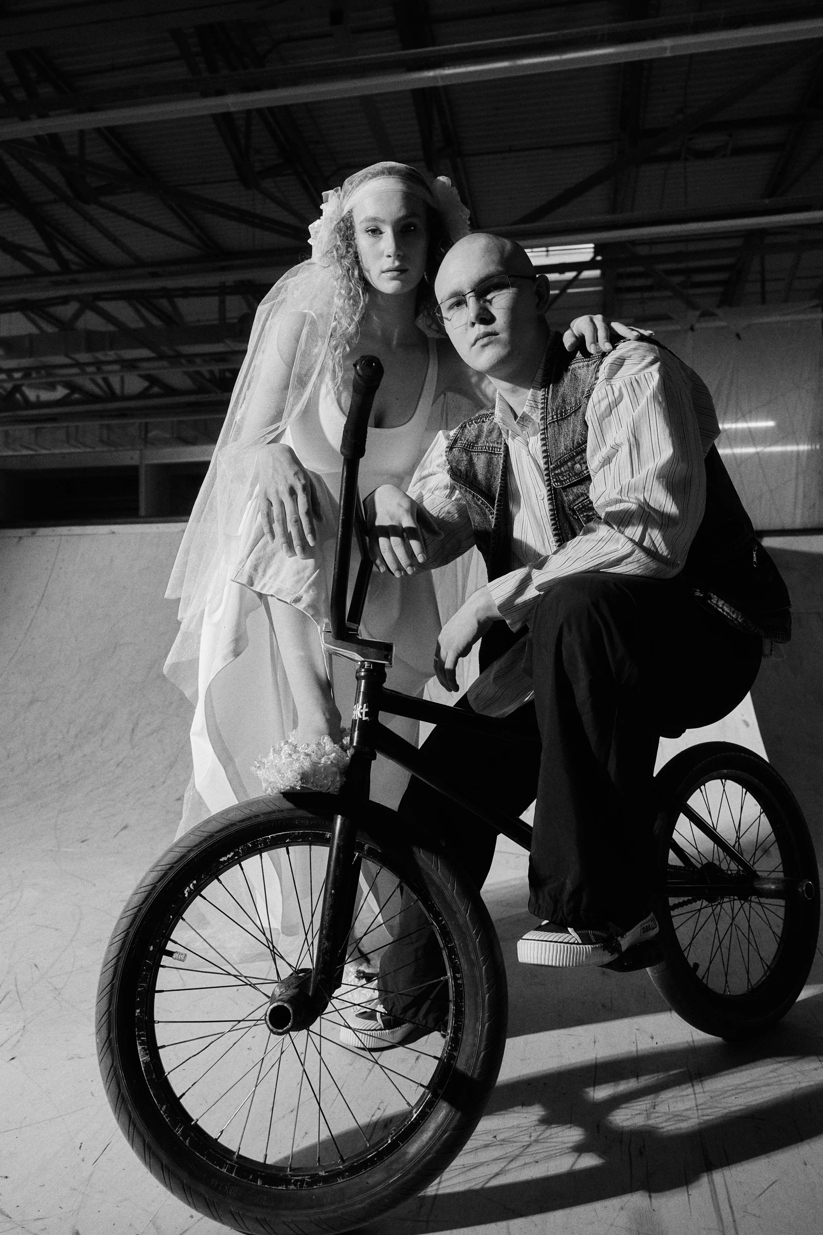 невеста и жених обнимаются у BMX-велосипеда в скейт-парке